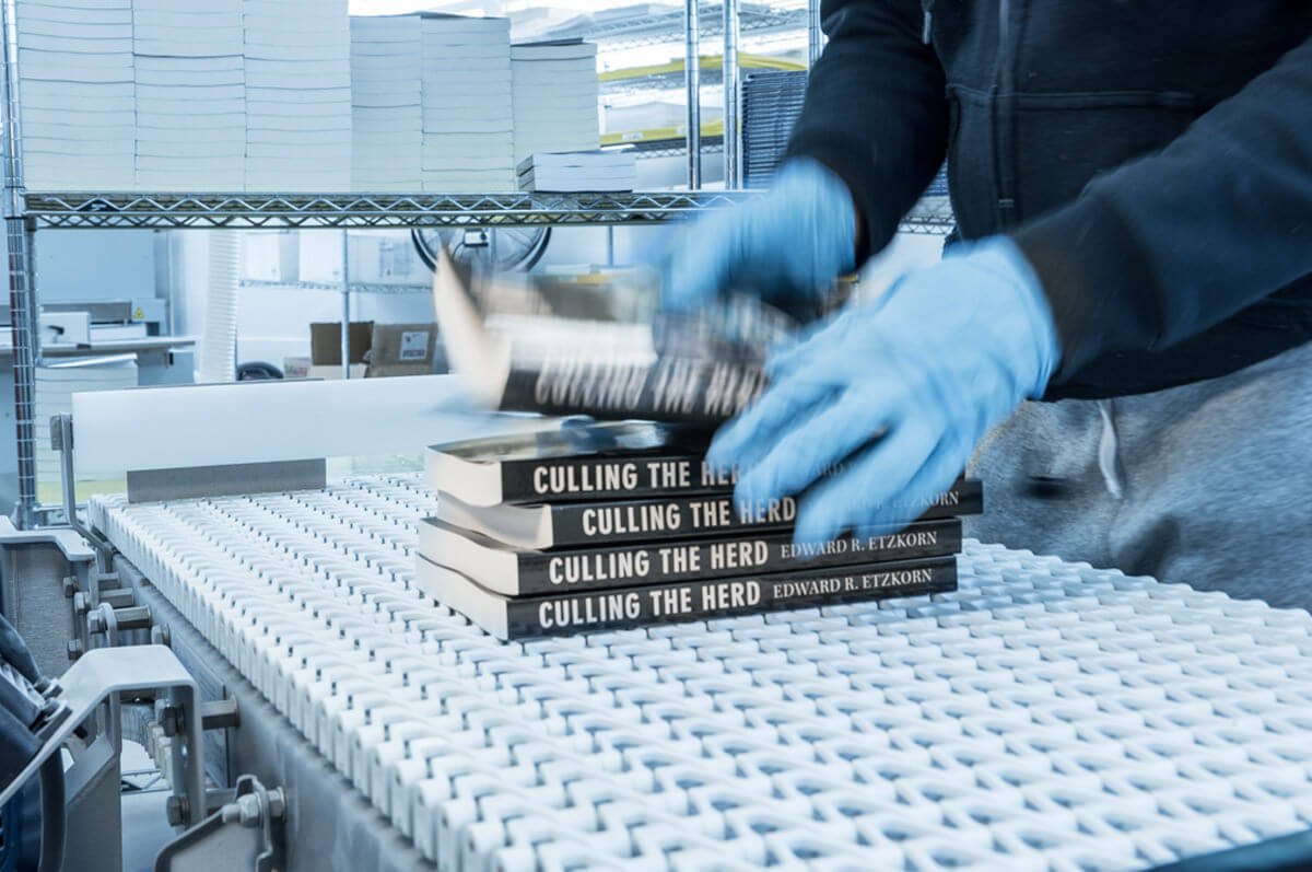 Freshly printed books on a production line, representing book publishing companies in San Francisco